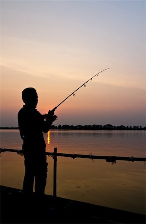 Silhouette of a man fishing with a beautiful lake background at sunset Stockbilder - Microstock & Abonnement, Bildnummer: 400-06332215