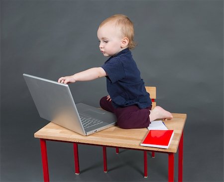 young child with laptop computer on wooden desk in grey background Stock Photo - Budget Royalty-Free & Subscription, Code: 400-06332277
