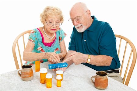 simsearch:400-06333333,k - Senior couple at the table, sorting their medications for the week.  White background. Foto de stock - Super Valor sin royalties y Suscripción, Código: 400-06333334