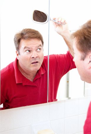 Mature man in his forties uses a mirror to check for bald patches in his hair. Stock Photo - Budget Royalty-Free & Subscription, Code: 400-06333343