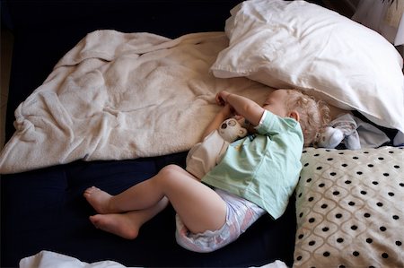 A child asleep  on the floor surrounded by pillows and blankets Stock Photo - Budget Royalty-Free & Subscription, Code: 400-06356415