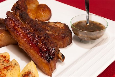 Grilled caramelized pork ribs served with garnish and Argentinian chimichurri sauce Stock Photo - Budget Royalty-Free & Subscription, Code: 400-06357706