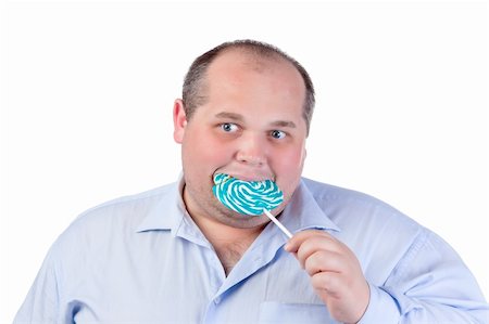 simsearch:400-07305387,k - Fat Man in a Blue Shirt, Eating a Lollipop, isolated Photographie de stock - Aubaine LD & Abonnement, Code: 400-06364556