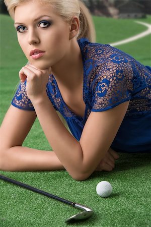 beautiful blonde girl plays golf with blue short dress and hig shoes, lying on the grass with golf-club and ball, looks in to the lens Photographie de stock - Aubaine LD & Abonnement, Code: 400-06365438