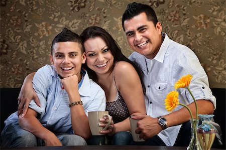simsearch:400-06366240,k - Happy Latino family of three embracing on a sofa Stockbilder - Microstock & Abonnement, Bildnummer: 400-06366245