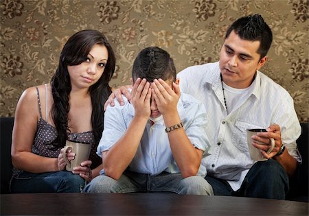 simsearch:400-06366240,k - Latino parents comforting sad male teenager with hands in face Stockbilder - Microstock & Abonnement, Bildnummer: 400-06366240