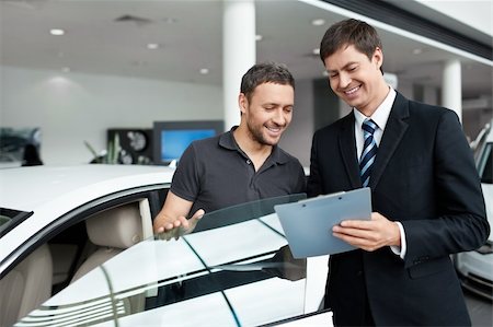 simsearch:400-06415950,k - Young man with a salesman in a motor show Stock Photo - Budget Royalty-Free & Subscription, Code: 400-06366600