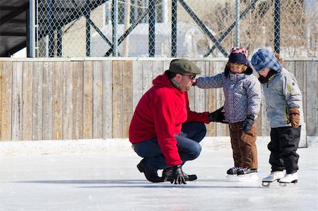 Family having fun at the outdoor skating rink in winter. Photographie de stock - Aubaine LD & Abonnement, Code: 400-06367505