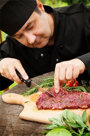 Cooking ingredients: marinated meat,oil,vinegar, herbs and vegetables. Chef is carving and marinating meat. Stock Photo - Budget Royalty-Free & Subscription, Code: 400-06388112