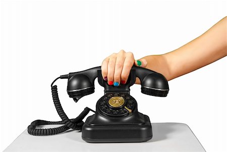 simsearch:400-07038627,k - A hand holding the handset of an old black vintage rotary style telephone isolated over white. Fotografie stock - Microstock e Abbonamento, Codice: 400-06389072