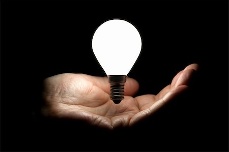 Floating lit lightbulb above a hand cupped on black background Stock Photo - Budget Royalty-Free & Subscription, Code: 400-06394949