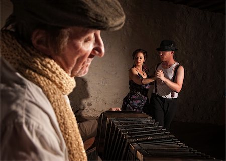 european traditional musical instruments - Two European tango dancers turning as squeezebox performer plays Stock Photo - Budget Royalty-Free & Subscription, Code: 400-06396086