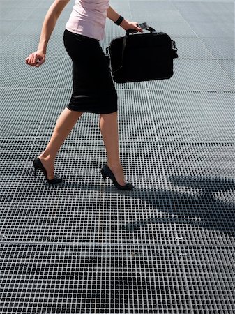 funny businesswoman shoes - cropped view of mid adult business woman walking on high heels, trying to balance on grating Stock Photo - Budget Royalty-Free & Subscription, Code: 400-06396946