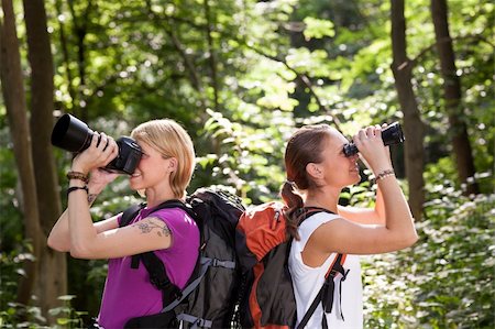simsearch:400-06396994,k - young people trekking among trees and looking at birds with binoculars. Horizontal shape, side view, waist up Stock Photo - Budget Royalty-Free & Subscription, Code: 400-06396995