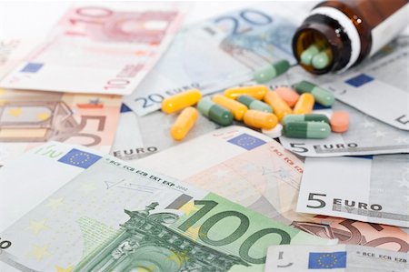 simsearch:400-04758612,k - Open bottle of pills and capsules on top of money, focus on money. Stock Photo - Budget Royalty-Free & Subscription, Code: 400-06391643