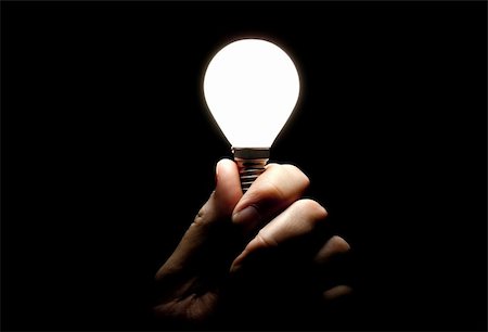 Lit lightbulb held in hand on black background Stock Photo - Budget Royalty-Free & Subscription, Code: 400-06393078