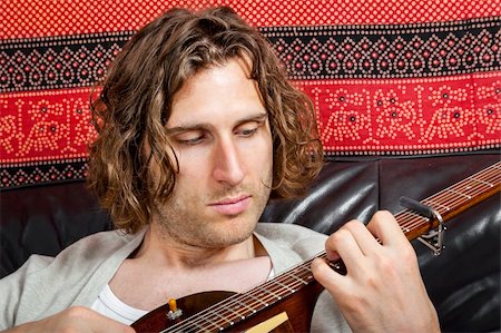 An image of a handsome guitar player with a curly hairdo Stock Photo - Budget Royalty-Free & Subscription, Code: 400-06393457