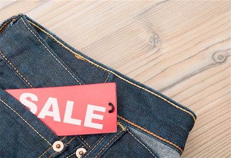 reduced sign in a shop - Red Sale Tag in Pocket of Blue Jeans Stock Photo - Budget Royalty-Free & Subscription, Code: 400-06393522