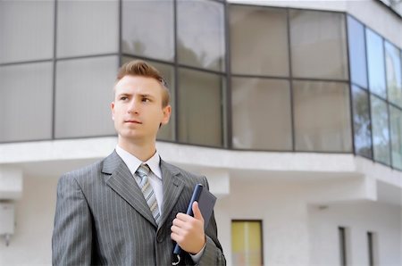 simsearch:400-06393704,k - businessman holds the notebook on the building background Stock Photo - Budget Royalty-Free & Subscription, Code: 400-06393705