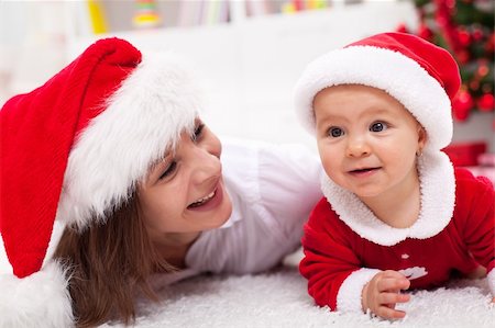 santa christmas hat women - Our first Christmas - mother and baby with santa hats laying on the floor Stock Photo - Budget Royalty-Free & Subscription, Code: 400-06408432