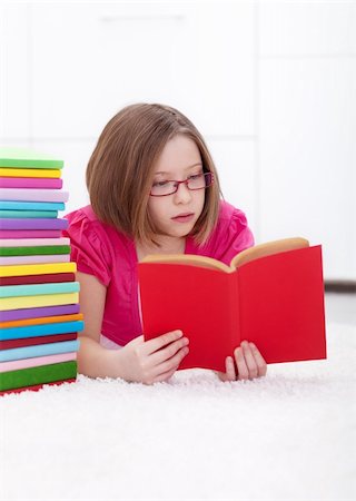 school girl holding pile of books - Young girl absorbed by a good book - reading and learning concept Stock Photo - Budget Royalty-Free & Subscription, Code: 400-06408445