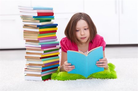 school girl holding pile of books - Young girl with lots of books reading on the floor Stock Photo - Budget Royalty-Free & Subscription, Code: 400-06408446