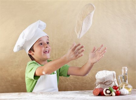 simsearch:400-06078465,k - Boy with chef hat preparing the pizza dough - kneading and stretching Stock Photo - Budget Royalty-Free & Subscription, Code: 400-06408513