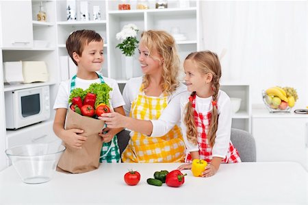 shopping bags in kitchen - Healthy nutrition concept with people in the kitchen unpacking the vegetables from grocery bag Stock Photo - Budget Royalty-Free & Subscription, Code: 400-06416953