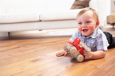 Young Boy Playing With Wooden Toy Car At Home Stock Photo - Budget Royalty-Free & Subscription, Code: 400-06417517