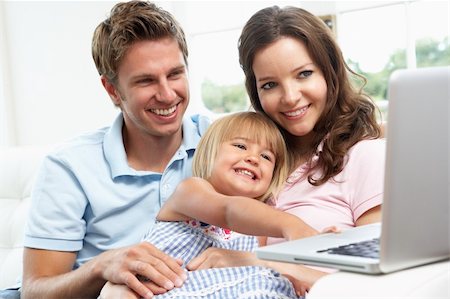 Family Sitting On Sofa Using Laptop At Home Stock Photo - Budget Royalty-Free & Subscription, Code: 400-06417667