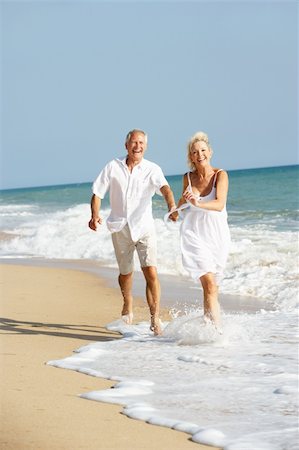 Senior Couple Enjoying Beach Holiday Foto de stock - Super Valor sin royalties y Suscripción, Código: 400-06417806