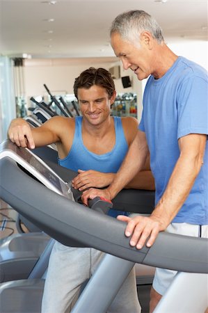 simsearch:400-06418716,k - Man Working With Personal Trainer On Running Machine In Gym Foto de stock - Royalty-Free Super Valor e Assinatura, Número: 400-06418715