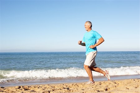 simsearch:400-06418716,k - Senior Man In Fitness Clothing Running Along Beach Foto de stock - Royalty-Free Super Valor e Assinatura, Número: 400-06419238