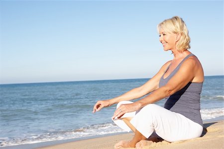 senior woman meditating - Senior Woman In Fitness Clothing Meditating On Beach Stock Photo - Budget Royalty-Free & Subscription, Code: 400-06419245