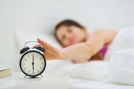 Closeup on woman hand reaching to turn off alarm clock Stock Photo - Budget Royalty-Free & Subscription, Code: 400-06419790