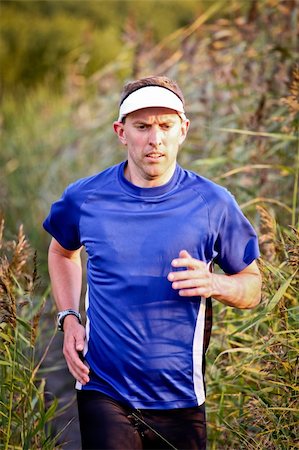 A man running through reed in nature Foto de stock - Royalty-Free Super Valor e Assinatura, Número: 400-06410876