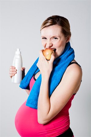 simsearch:400-04176771,k - Healthy pregnant woman eating an apple after exercising, holding a water bottle Stock Photo - Budget Royalty-Free & Subscription, Code: 400-06413464