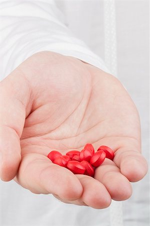 Close-up photograph of a hand holding red tablets. Stock Photo - Budget Royalty-Free & Subscription, Code: 400-06424551