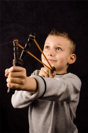 estilingue - Studio photo of a young boy with slingshot Foto de stock - Royalty-Free Super Valor e Assinatura, Número: 400-06427585