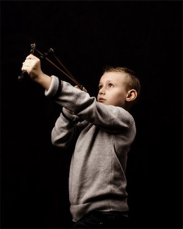 estilingue - Little boy shooting with a slingshot Foto de stock - Royalty-Free Super Valor e Assinatura, Número: 400-06427590