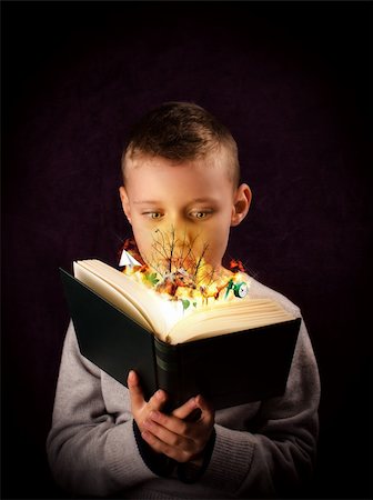 silent47 (artist) - Young boy reading and looking at a magic book Foto de stock - Super Valor sin royalties y Suscripción, Código: 400-06427699