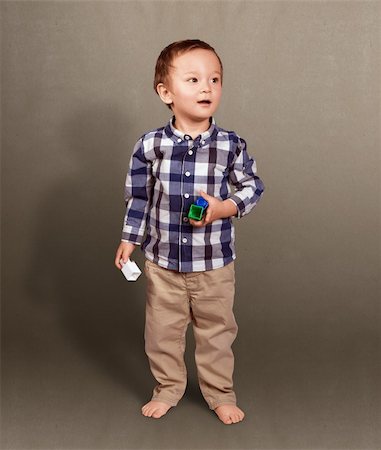 simsearch:400-08415463,k - Cute baby standing in studio with toys in his hands Stock Photo - Budget Royalty-Free & Subscription, Code: 400-06429602