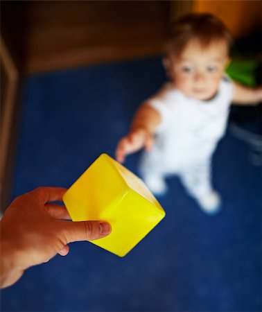 simsearch:400-06737087,k - Little handsome boy takes the yellow cube. Shallow dof, focus is on the cube. Fotografie stock - Microstock e Abbonamento, Codice: 400-06429688