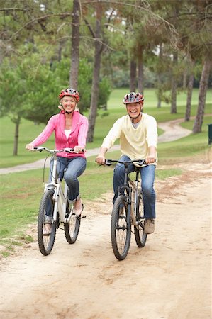 senior couple riding bicycles - Senior couple riding bicycle in park Stock Photo - Budget Royalty-Free & Subscription, Code: 400-06420430