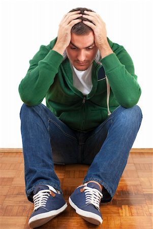 Young depressed male sitting holding his head with both hands Stock Photo - Budget Royalty-Free & Subscription, Code: 400-06420663