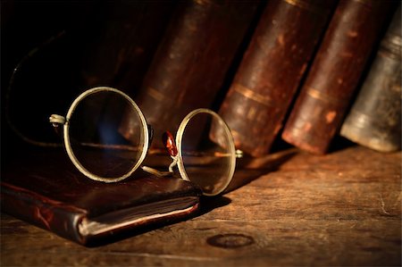 Old spectacles on leather notebook on background with old books Foto de stock - Super Valor sin royalties y Suscripción, Código: 400-06420707