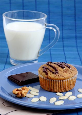 simsearch:400-05692108,k - Closeup image of a muffin cake on a blue plate with almond chips, walnut, a piece if dark chocolate and a glass of milk Foto de stock - Super Valor sin royalties y Suscripción, Código: 400-06421193