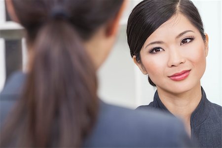 Portrait of a beautiful young Asian Chinese woman or businesswoman in office meeting with female colleague Stock Photo - Budget Royalty-Free & Subscription, Code: 400-06422328