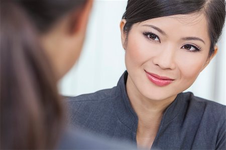 Portrait of a beautiful young Asian Chinese woman or businesswoman in office meeting with female colleague Stock Photo - Budget Royalty-Free & Subscription, Code: 400-06422330