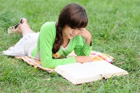 reading book open air - Girl reading a book lying on the grass Stock Photo - Budget Royalty-Free & Subscription, Code: 400-06422822